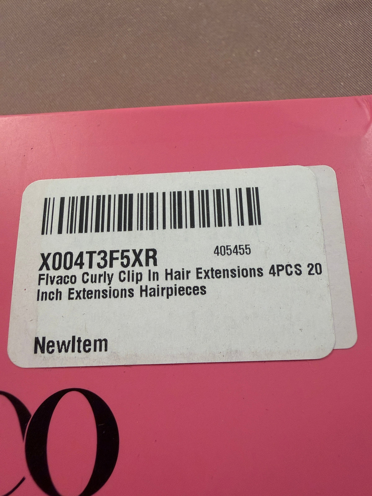 Curly hair extensions in a clear bag inside the open box