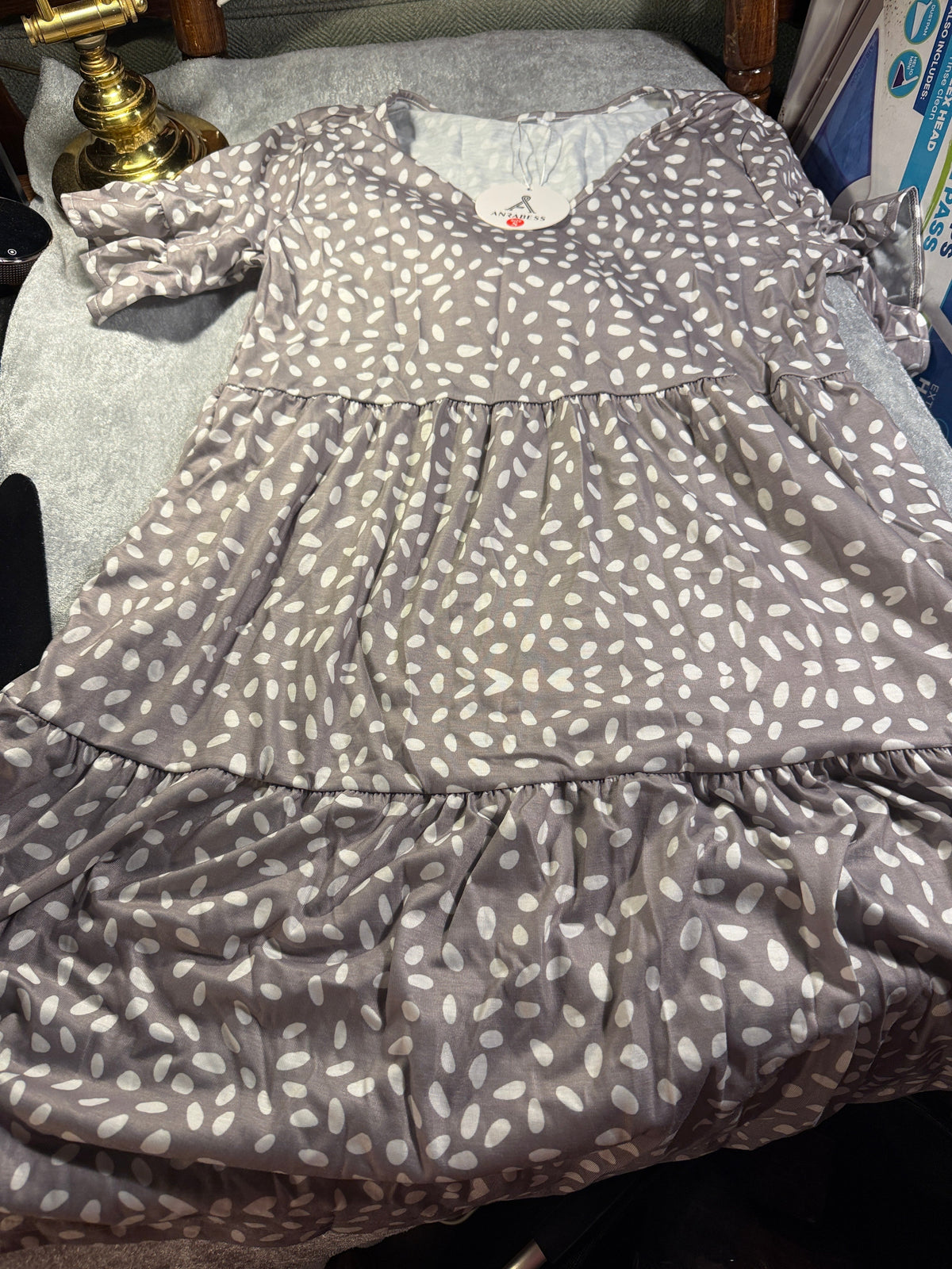 Tape measure shown on a detail of the taupe and ivory spotted dress