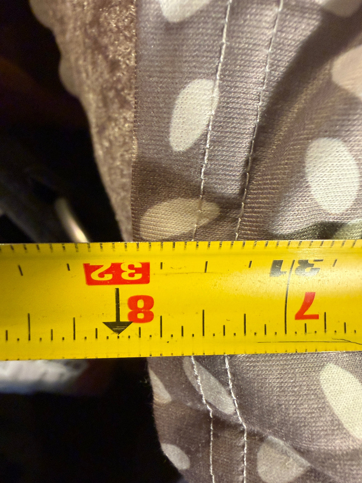 Tape measure shown on the taupe and ivory spotted dress